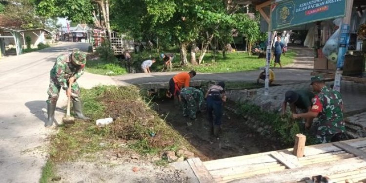 Koramil 0111/Pagelaran Bersama Warga Bersihkan Sampah Di Saluran Air