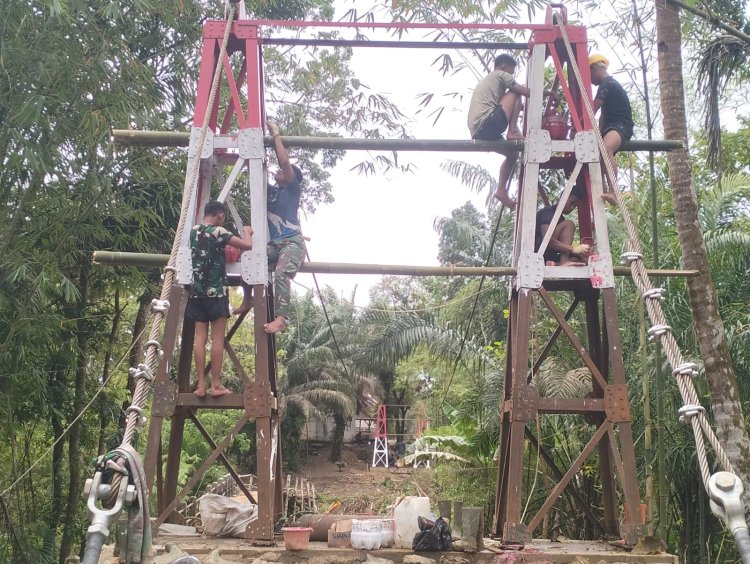 Pembangunan Jembatan Gantung Belengbeng Terus Dikebut di Bulan Ramadhan  Babinsa Koramil 0116/Cikeusik, Personel Yon TP 842/Badak Sakti, dan Warga Laksanakan Pemasangan Sling & Paving Blok
