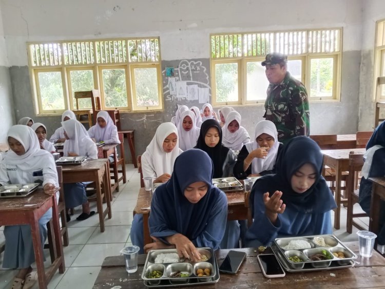 Babinsa Koramil 0107/Sukaresmi Dampingi Pendistribusian Program Makan Bergizi Gratis (MBG) di Kecamatan Cisata